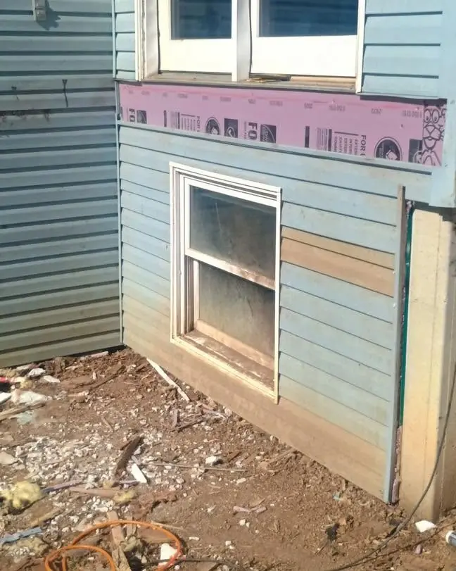 The same wall with new sheathing and siding going on